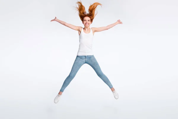 Foto em tamanho completo de engraçado positivo penteado vermelho senhora salto desgaste branco top jeans isolado no fundo de cor brilhante — Fotografia de Stock