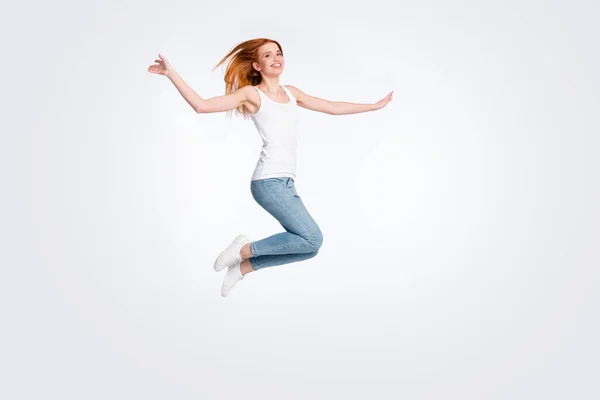 Full body photo of funky cheerful red hairdo lady jump wear white top jeans isolated on bright color background Royalty Free Stock Photos