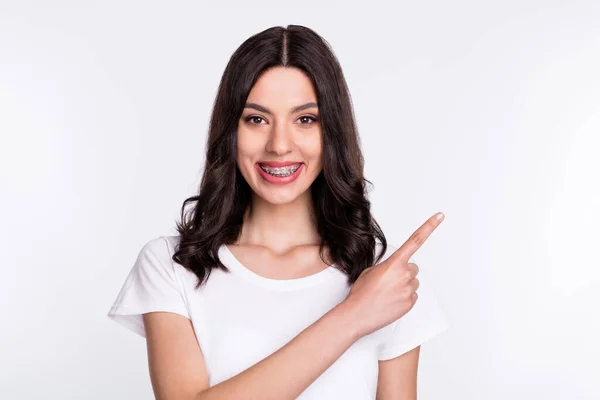 Foto di divertente affascinante giovane signora indossare abbigliamento casual sorridente indicando dito vuoto spazio isolato colore bianco sfondo — Foto Stock
