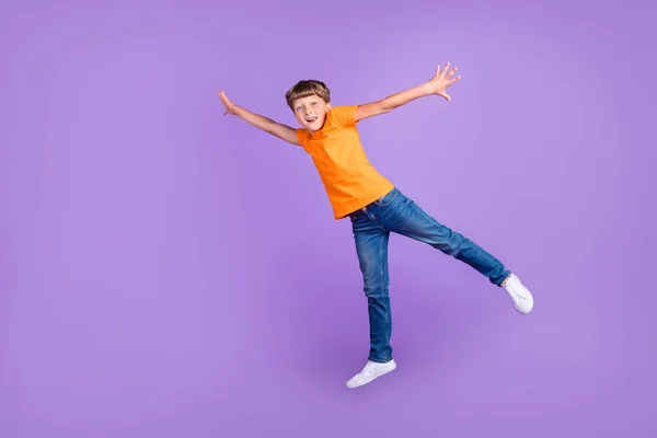 Повна довжина тіла фото хлопчик стрибає недбало ловити порожній простір ізольований пастельний фіолетовий кольоровий фон — стокове фото