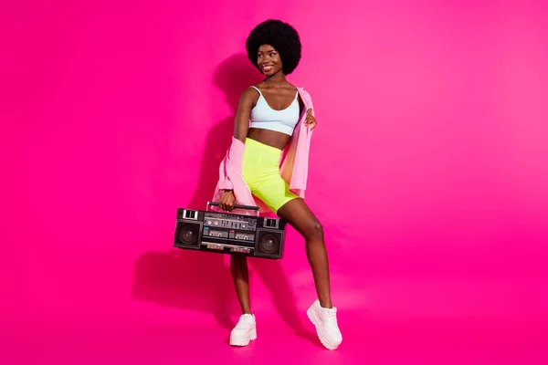 魅力的な光沢のある黒い肌の女性の写真カジュアルシャツを保持ブームボックスを見て空のスペース笑顔孤立ピンク色の背景 — ストック写真