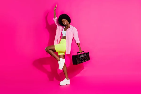 Foto von glänzenden funky dunkle Haut Dame tragen lässig Hemd tanzen hält Boom-Box suchen leeren Raum lächelnd isoliert rosa Hintergrund — Stockfoto