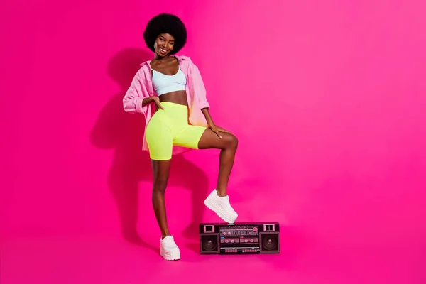 Fénykép a bájos édes sötét bőr hölgy viselni alkalmi ing álló boom box mosolygós elszigetelt rózsaszín szín háttér — Stock Fotó
