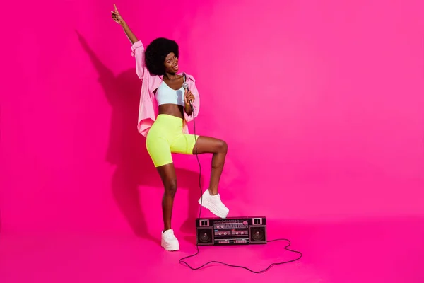 Fénykép édes imádnivaló sötét bőr hölgy viselni alkalmi ing álló boom box éneklés karaoke mosolygós elszigetelt rózsaszín háttér — Stock Fotó
