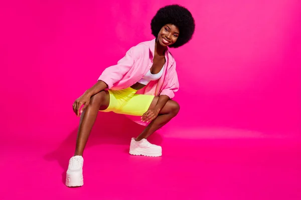 Foto de linda encantadora mujer de piel oscura usar camisa casual bailando espacio vacío aislado color rosa fondo — Foto de Stock