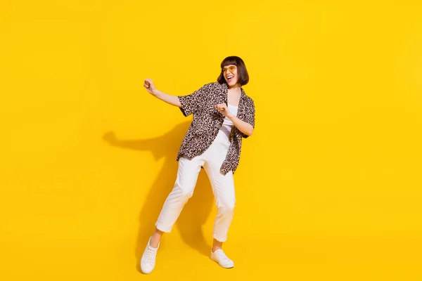 Foto em tamanho completo de senhora louca dança desgaste óculos camisa calças tênis isolado no fundo de cor amarela — Fotografia de Stock