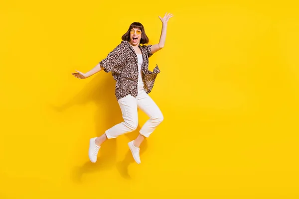Full length body size view of pretty carefree crazy cheerful girl jumping having fun rejoicing isolated bright yellow color background — Stockfoto