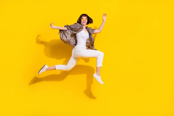 Çekici, neşeli, atlama hareketli, parlak sarı arkaplan görünümlü, uzun boylu, atlama hareketli bir kız. — Stok fotoğraf
