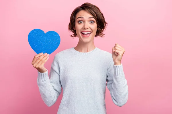 Foto de mulher feliz espantado segurar papel coração vencedor sorrir sorte sentimentos isolados no fundo cor-de-rosa — Fotografia de Stock