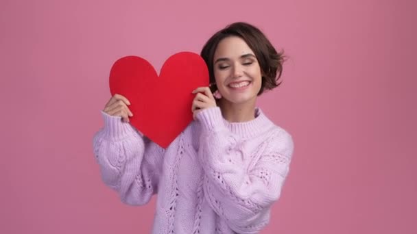 Encantadora dama celebrar rojo corazón novio regalo aislado pastel color fondo — Vídeos de Stock