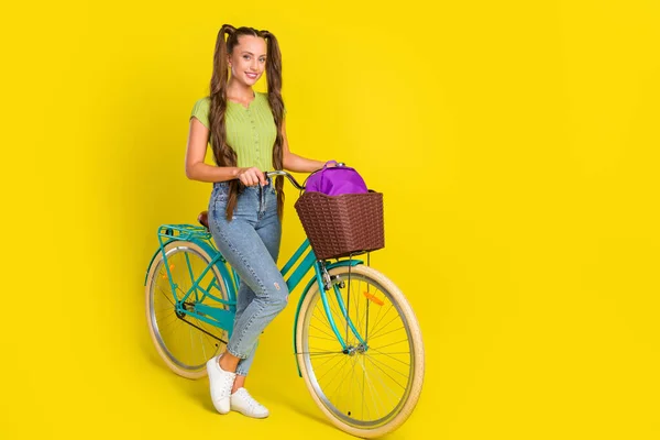 Comprimento total tamanho do corpo vista de linda menina alegre engraçado andar de bicicleta isolada sobre fundo de cor amarela vívida — Fotografia de Stock