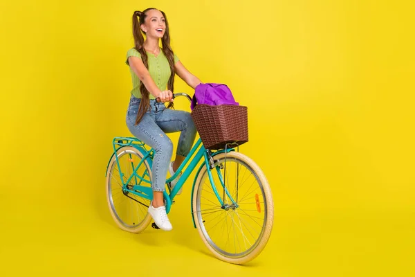 Comprimento total do corpo tamanho vista de menina alegre atraente andar de bicicleta se divertindo isolado sobre fundo de cor amarela brilhante — Fotografia de Stock