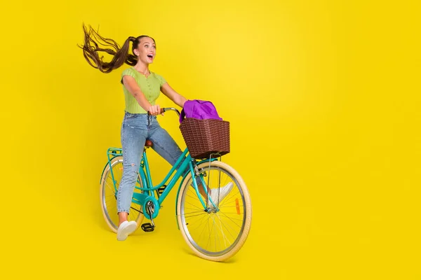 Comprimento total do corpo tamanho vista de menina alegre muito engraçado andar de bicicleta enganando se divertindo isolado sobre fundo de cor amarela brilhante — Fotografia de Stock