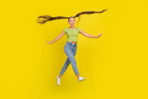 Повна довжина вигляд тіла приваблива весела дівчина стрибає гарний настрій обманює ізольовані на яскраво-жовтому кольоровому фоні — стокове фото