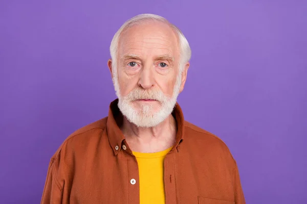 Foto do homem mais velho grave vestindo camisa marrom isolado sobre fundo de cor violeta vívida — Fotografia de Stock