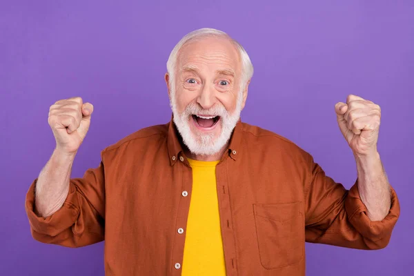 Φωτογραφία του funky ηλικιωμένος άνθρωπος γροθιές φωνάξει φορώντας καφέ πουκάμισο απομονώνονται πάνω από ζωντανή βιολετί φόντο χρώμα — Φωτογραφία Αρχείου