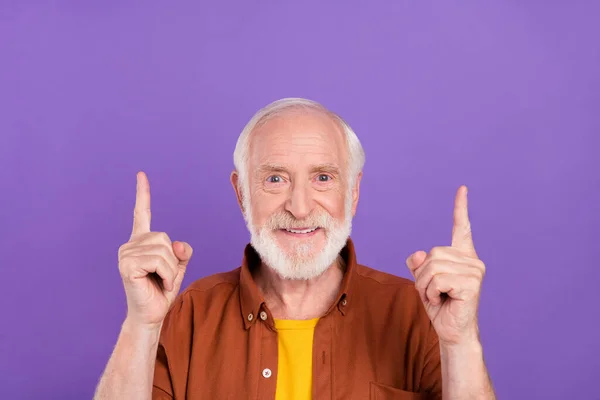 Mor arkaplan üzerine izole edilmiş kahverengi gömlek giyen iyimser yaşlı adam indeksi fotoğrafı — Stok fotoğraf