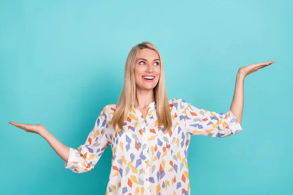 Photo of impressed young blond lady look empty space wear printed blouse isolated on teal color background — 图库照片
