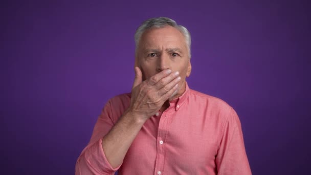 Homem de meia idade esconder lábios palma dizer notícias isolado cor vibrante fundo — Vídeo de Stock