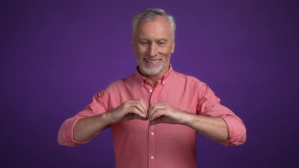 Caballero de mediana edad hacen manos en forma de corazón degradado aislado color fondo — Vídeo de stock