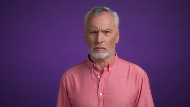 Middelbare leeftijd man onder de indruk boodschap geïsoleerde levendige kleur achtergrond — Stockvideo