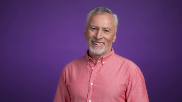 Zadowolony mężczyzna w średnim wieku patrzeć w aparacie odizolowane żywe tło kolorów — Wideo stockowe