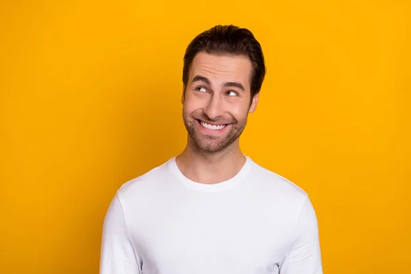 Portrait of satisfied candid person toothy smile look interested empty space isolated on yellow color background Royalty Free Stock Images