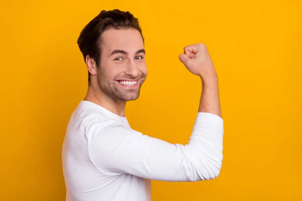 Profiel portret van tevreden blij persoon stralen glimlach arm tonen biceps geïsoleerd op gele kleur achtergrond — Stockfoto