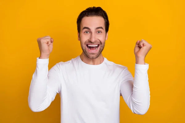 Portret van positieve extatische man hef vuisten schreeuwen ja vieren bereiken geïsoleerd op gele kleur achtergrond — Stockfoto