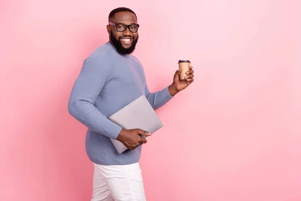 Fotografie veselý chlap oblečený svetr ruční brýle držení gadget čaj prázdný prostor izolované růžové barvy pozadí — Stock fotografie