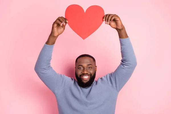 Foto de hombre romántico celebrar figura del corazón levantar las manos invitar fecha desgaste camisa gris aislado color rosa fondo — Foto de Stock