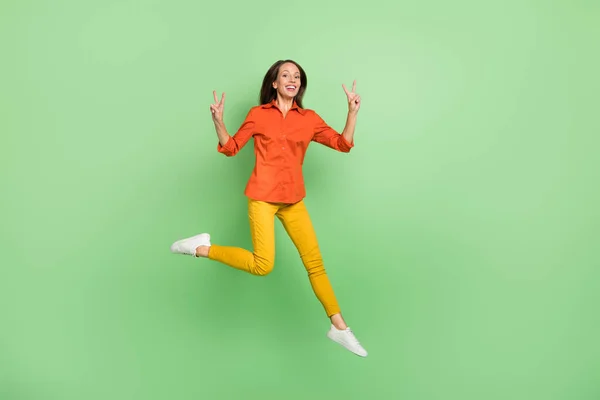 In voller Länge Foto der fröhlichen reifen Dame zeigen Finger V-Symbol Pullover isoliert über grüne Farbe Hintergrund — Stockfoto