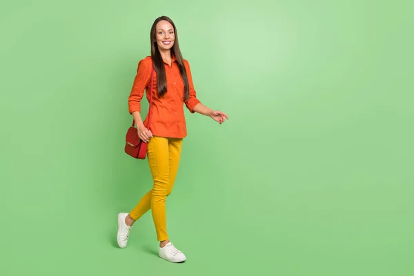 Photo de profil pleine grandeur côté de jeune femme adorable marchant temps libre isolé sur fond de couleur verte — Photo