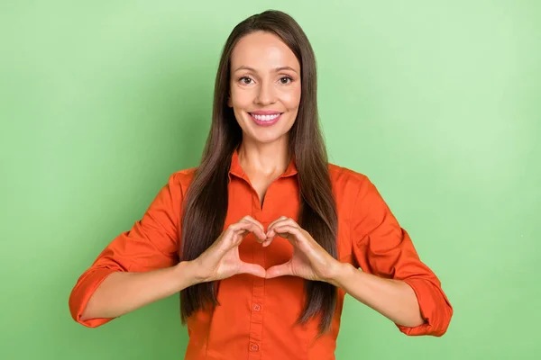 명랑 한 젊은 여성의 사진은 녹색 배경 위에 고립된 작은 심장의 상징인 로맨틱 한 손을 보여준다 — 스톡 사진