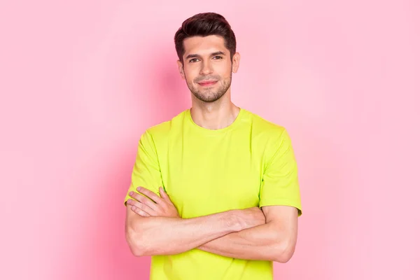 Foto von optimistischen Brunet Frisur Millennial Kerl verschränkte Arme tragen grünes T-Shirt isoliert auf rosa Hintergrund — Stockfoto