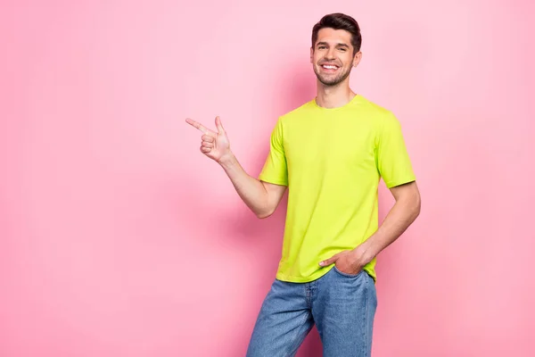 Foto von lustigen Brunet Frisur junger Kerl zeigen leeren Raum tragen grünes T-Shirt isoliert auf rosa Hintergrund — Stockfoto