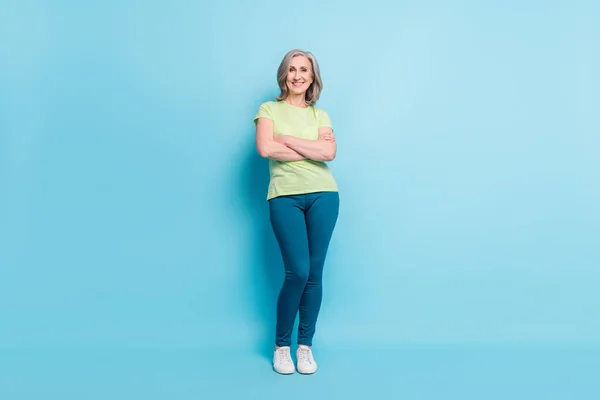 Pleine longueur taille du corps photo senior femme d'affaires souriant avec les mains croisées isolé fond de couleur bleu pastel — Photo