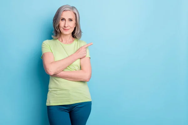 Foto portret oude vrouw tonen vinger lege ruimte adviseren geïsoleerde pastel blauwe kleur achtergrond — Stockfoto