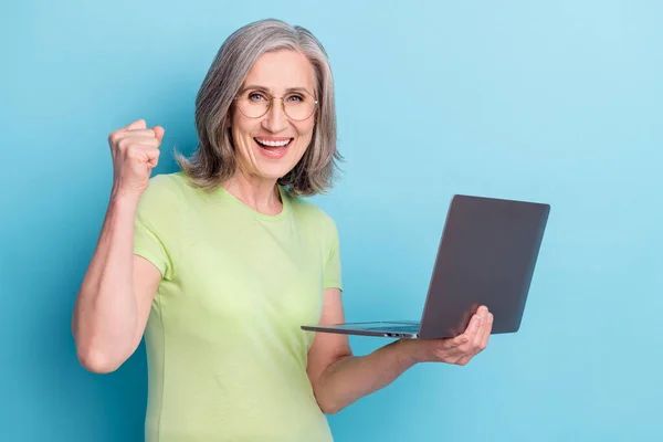 Foto di allegra donna anziana felice tenere per mano il vincitore del computer buon umore isolato su sfondo di colore blu — Foto Stock