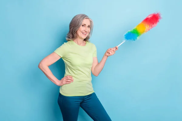 Foto van positieve vrolijke oude positieve vrouw houden hand taille stofdoek geïsoleerd op pastel blauwe kleur achtergrond — Stockfoto