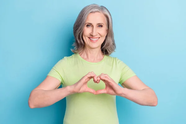 Foto de feliz agradável encantador velha mulher fazer dedos forma de coração isolado no fundo de cor azul pastel — Fotografia de Stock