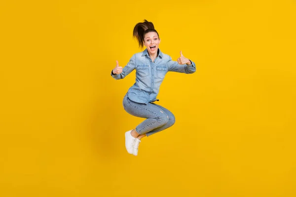 Pleine longueur taille du corps photo jeune jolie fille sautant vers le haut montrant pouce geste isolé couleur jaune vif arrière-plan — Photo