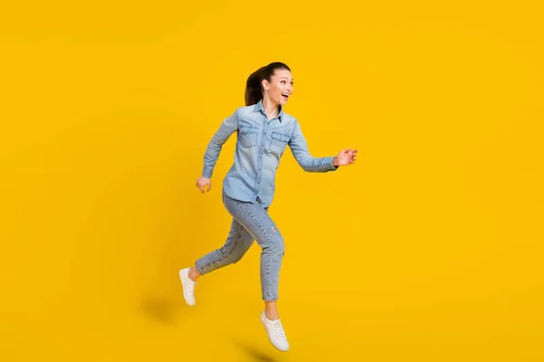 Comprimento total tamanho do corpo sorridente menina pulando em execução à venda isolado vívido cor amarela fundo — Fotografia de Stock