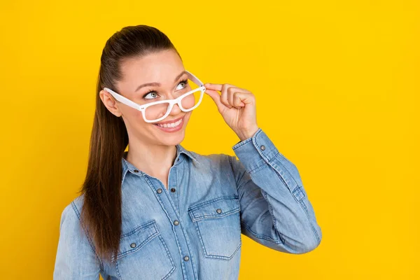 Foto retrato mujer buscando copyspace sonriendo feliz usando gafas aislado vívido color amarillo fondo — Foto de Stock