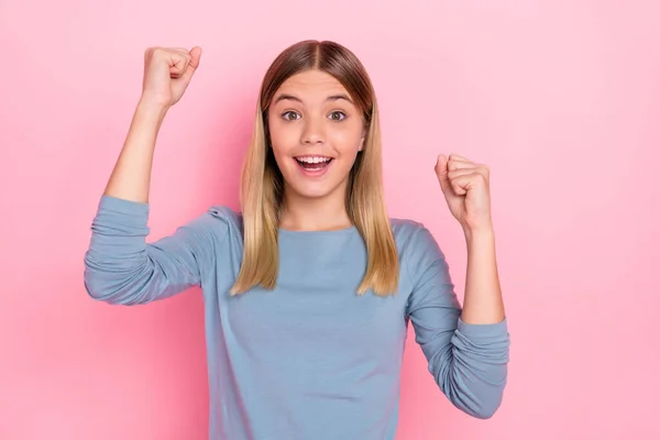 Фото молодой взволнованной девушки радоваться победе счастливые кулаки руки торжествуют изолированы на розовом фоне — стоковое фото