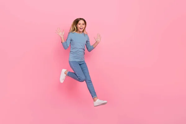 Foto de cuerpo completo de la joven chica bonita caminar salto ola brazos hola energético aislado sobre fondo de color rosa —  Fotos de Stock