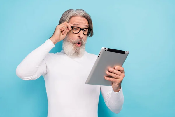 Retrato de atraente atordoado homem de cabelos grisalhos usando gadget leitura nova mídia post smm isolado sobre fundo de cor azul brilhante — Fotografia de Stock