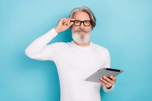 Retrato de homem de cabelos grisalhos alegre atraente usando dispositivo gadget blogging tocando especificações isoladas sobre fundo de cor azul brilhante — Fotografia de Stock