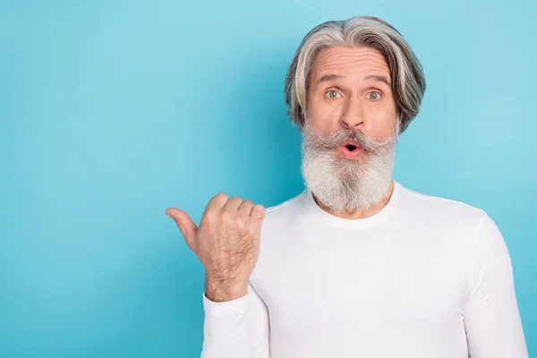 Portrait de séduisant homme aux cheveux gris étonné démontrant la direction de l'espace de copie publicitaire isolé sur fond de couleur bleu vif — Photo