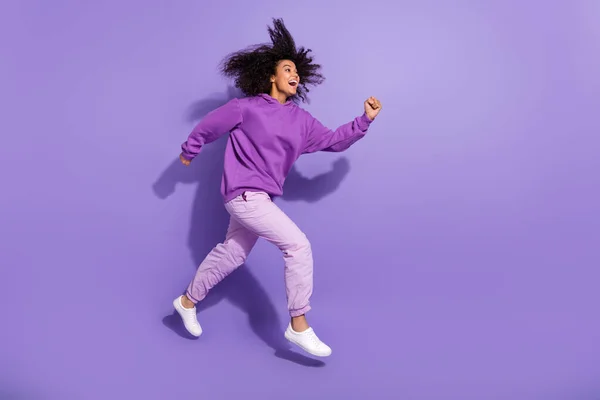 Full length profile photo of excited amazed girl running hurry look empty space isolated on purple color background — 图库照片